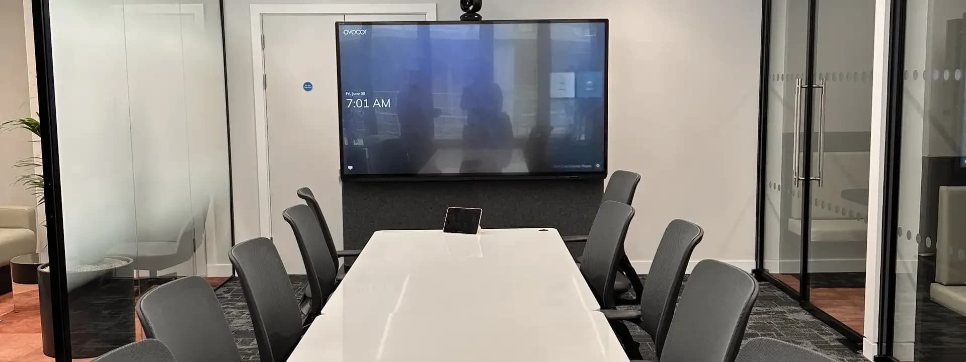Tabletop touch controller on a meeting table in front of a display